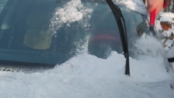 一个人把雪从车上抹去 冬天的时候 人在街上把雪从他的车上抹去 — 图库视频影像