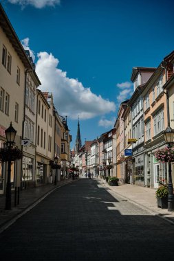 Muhlhausen, Almanya-10 07 2024. Güneşli bir günde canlı ve renkli bir mimarinin sergilendiği pitoresk bir kasabada büyüleyici ve antika bir cadde.
