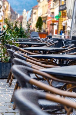 Avluda boş ahşap masaları ve sandalyeleri olan açık hava kafesi. Rahatlamaya ve boş zamanlara davet etmek.