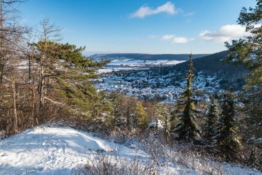 İzole edilmiş köy ve buzlu nehir içeren huzurlu kış manzarası, açık vadinin altındaki sakin karla kaplı bir köy.