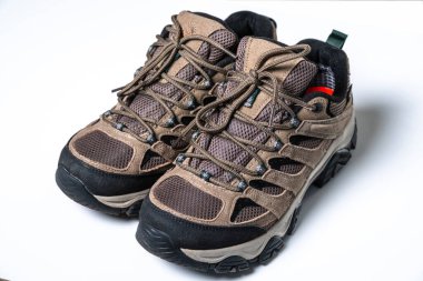 Beyaz arka planda kahverengi yürüyüş ayakkabıları üst süet, güçlendirilmiş ayak başlığı, agresif sürüklenmiş taban, metal.