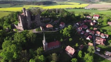 Ortaçağ Şatosu Tepesi Köyü Yoğun Orman ve Sarı Tecavüz Tohumu Tarlaları, Güneş Işığı Bulutları Yumuşak Gölgeler, Kıvrımlı Ülke Yolu. Hanstein Kalesi, Almanya.