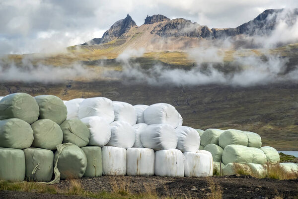 Hay packs in scenic countryside, agriculture in Iceland.