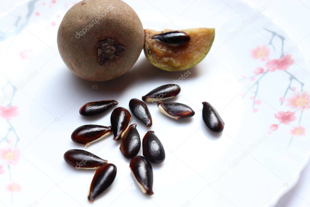 tasty and healthy sapodilla and seeds on white