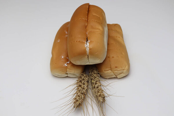 вкусный и здоровый хлеб и спелые пшеницы на белом фоне