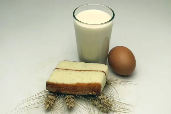 cake and ripe wheat and egg and milk and atta on white background