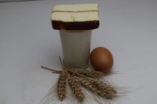 cake and ripe wheat and egg and milk and atta on white background