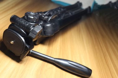 fotoğraf için ahşap masanın üzerinde siyah renkli tripod.