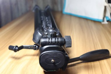 fotoğraf için ahşap masanın üzerinde siyah renkli tripod.