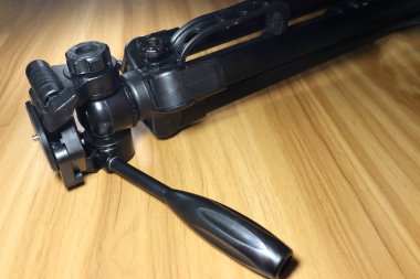 fotoğraf için ahşap masanın üzerinde siyah renkli tripod.