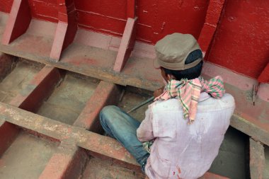 Makine ve ekipmanlı bir tekne onarım işçisi.