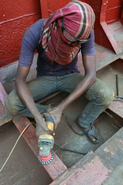 Makine ve ekipmanlı bir tekne onarım işçisi.