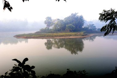 Göl ve orman manzarası, gökyüzü kapalı bir sabah