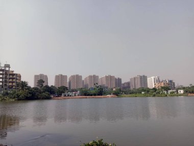 Gökyüzü manzaralı şehirde balık avlamak için göl