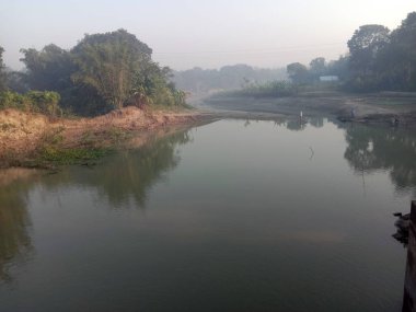 Göl ve orman manzarası, gökyüzü kapalı bir sabah