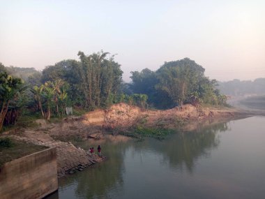 Göl ve orman manzarası, gökyüzü kapalı bir sabah