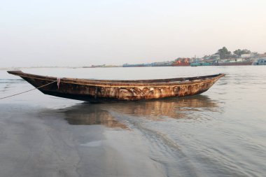 Nehirde siyah renkli ahşap balıkçı teknesi