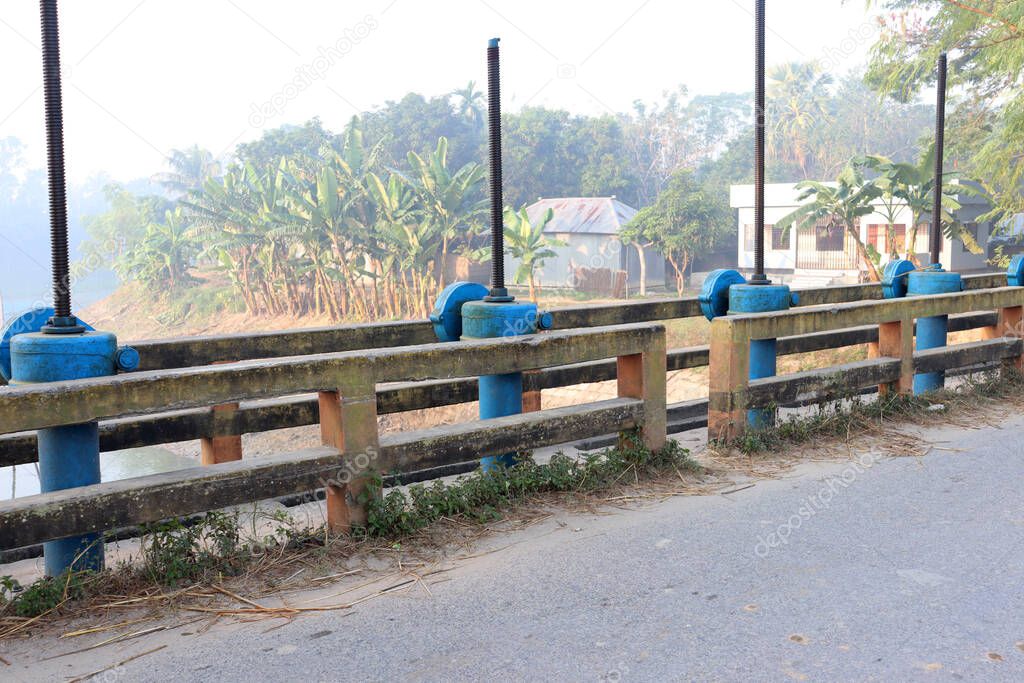 blue colored switch gate lock on bridge for water control