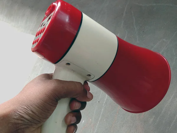 red and white colored megaphone speaker for Advertising & Publishing with hand
