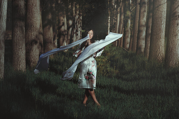 Beautiful woman dancing in ethereal forest