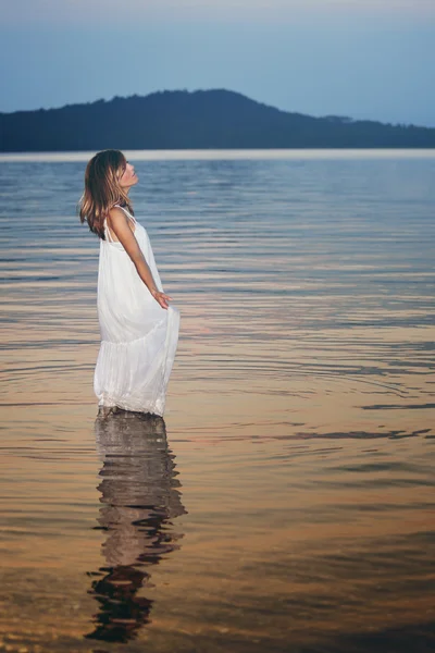 Donna in posa in un lago al tramonto — Foto Stock