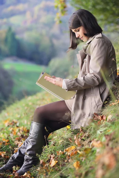 Elegant woman reading a book in autumn light — Stock Photo, Image