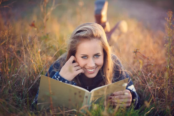 Beautiful blue eyes woman reading a book outdoor — Stock Photo, Image