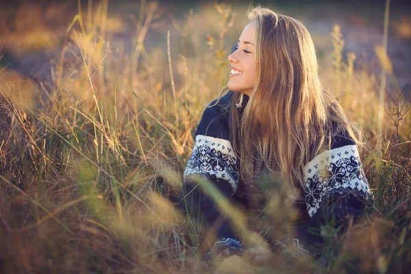 Молодая улыбающаяся девушка позирует в поле — стоковое фото