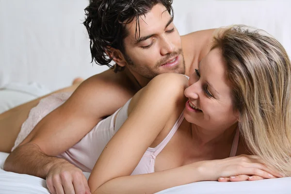 Joyful couple smiling and happy in bed — Stock Photo, Image