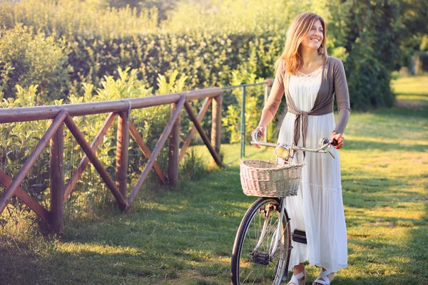 Jeune femme souriante avec vélo vintage — Photo