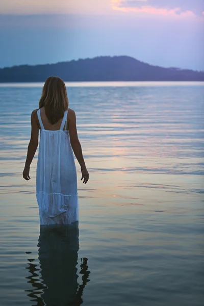 湖泊水体中的女人看着软紫色日落 — 图库照片