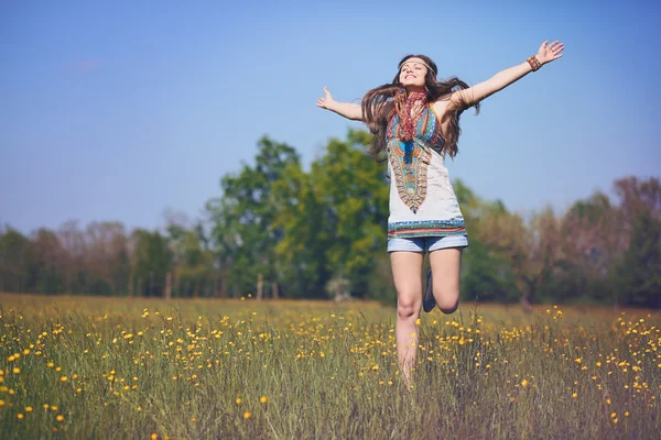 Happy and smiling hippie woman jumps — Stock Photo, Image