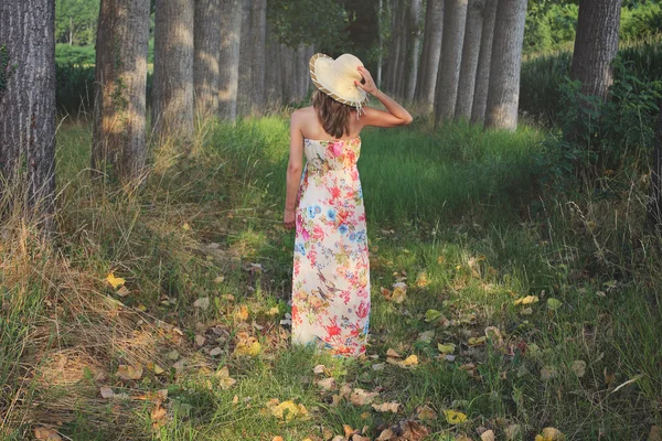 Kvinna med blommiga klänning och sommaren hatt — Stockfoto