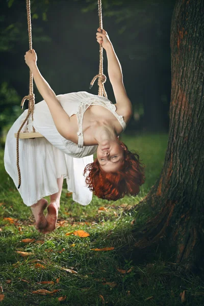 Beautiful woman with eyes closed on a swing — Stock Photo, Image
