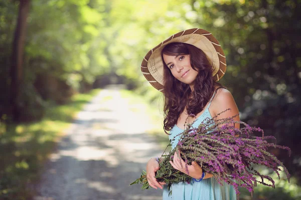 Lachende mooie vrouw met wilde bloemen — Stockfoto