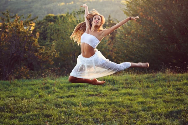 Krásný klasický tanečník skákání v západu slunce světlo — Stock fotografie