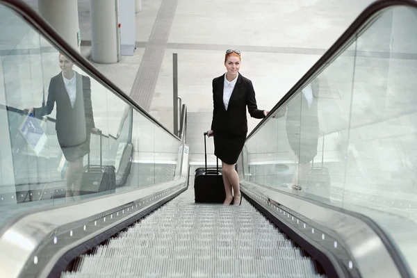 Mujer de negocios sonriente en escaleras mecánicas — Foto de Stock