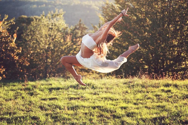 Bella ginnasta in un salto difficile all'aperto — Foto Stock