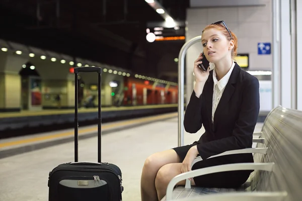 Beautiful manager with cellphone at train station — Stock Photo, Image