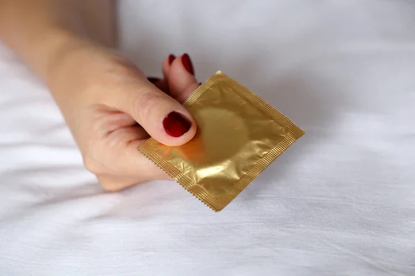 Kobieta Czerwonymi Paznokciami Prezerwatywą Kobieta Leżąca Łóżku Antykoncepcja Bezpieczny Seks — Zdjęcie stockowe