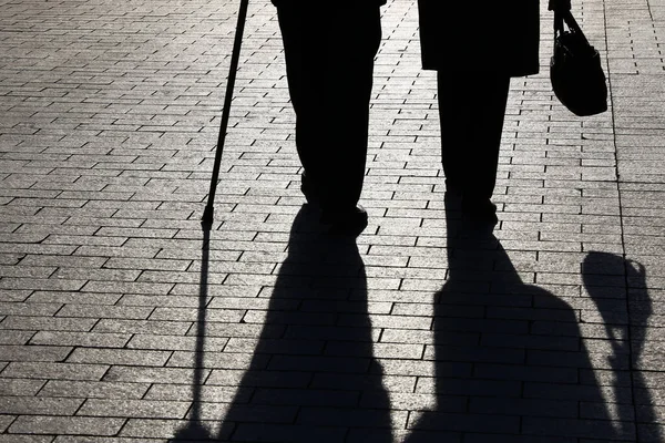 Siluetas Sombras Dos Ancianos Caminando Con Bastón Bolso Calle Pareja —  Fotos de Stock