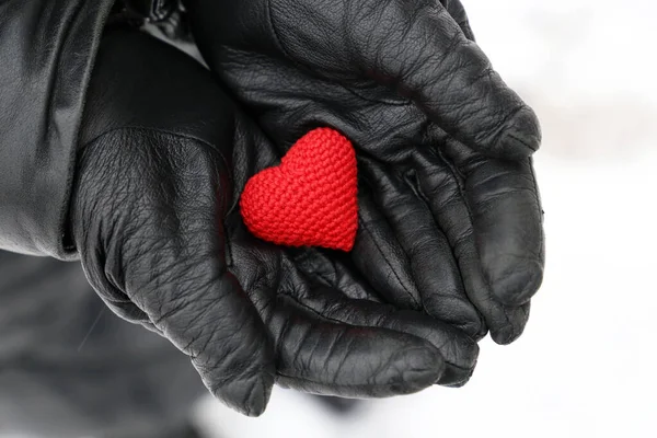 Rode Gebreide Hart Vrouwelijke Handen Zwart Lederen Handschoenen Sneeuw Achtergrond — Stockfoto