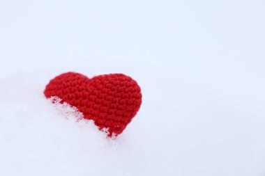 Karda sevgililer günü kalbi. Kırmızı örülmüş aşk sembolü, kış tatili için arka plan