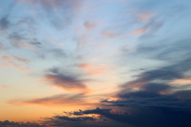 Renkli gökyüzünde gün batımı, pembe ve turuncu güneş ışığında bulutlar. Yumuşak renklerle arkaplan için resim gibi manzara