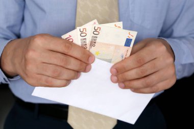 Avro banknotları erkeklerin elinde, iş kıyafetleri içinde beyaz zarflı bir adam. Nakit, gelir, rüşvet veya maaş kavramı