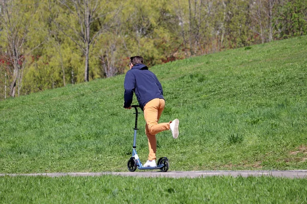 Człowiek Jeździ Skuterze Elektrycznym Ulicy Zielonym Wzgórzu Jazda Skuterze Elektrycznym — Zdjęcie stockowe