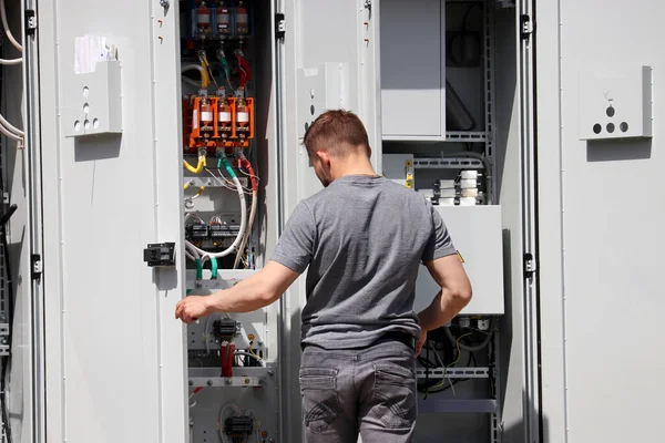 Electrician engineer working on the electrical distribution board. Repair works, street lighting system