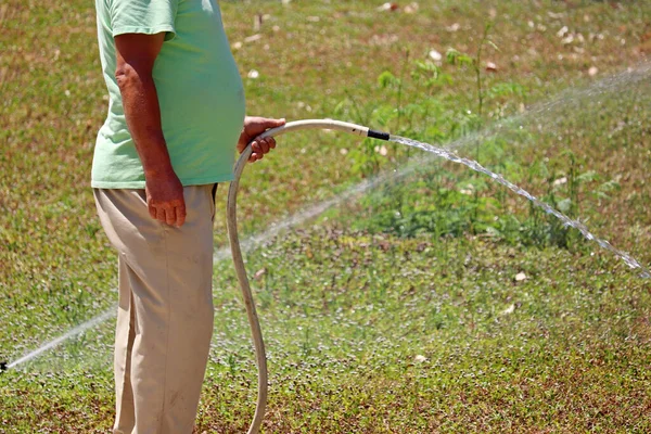 Man Hose His Hand Watering Grass Gardener Takes Care Lawn — Fotografia de Stock