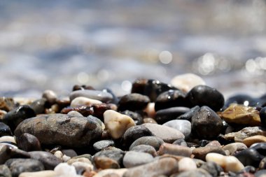 Deniz dalgalarının bulanık arka planında çakıl taşları. Yaz tatili kavramı