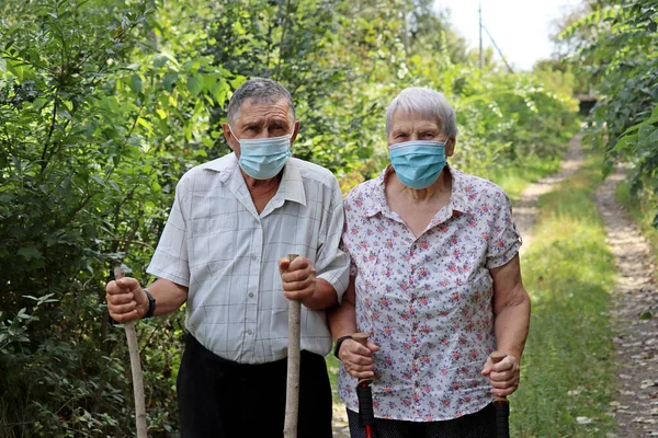 Äldre Par Skyddande Ansiktsmasker Promenader Med Käppar Naturen Bakgrund Säkerhet — Stockfoto